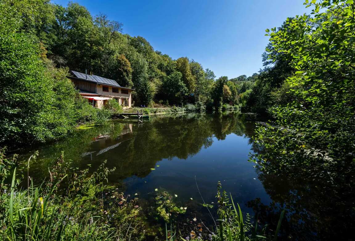 La maison et son étang vus depuis la rive