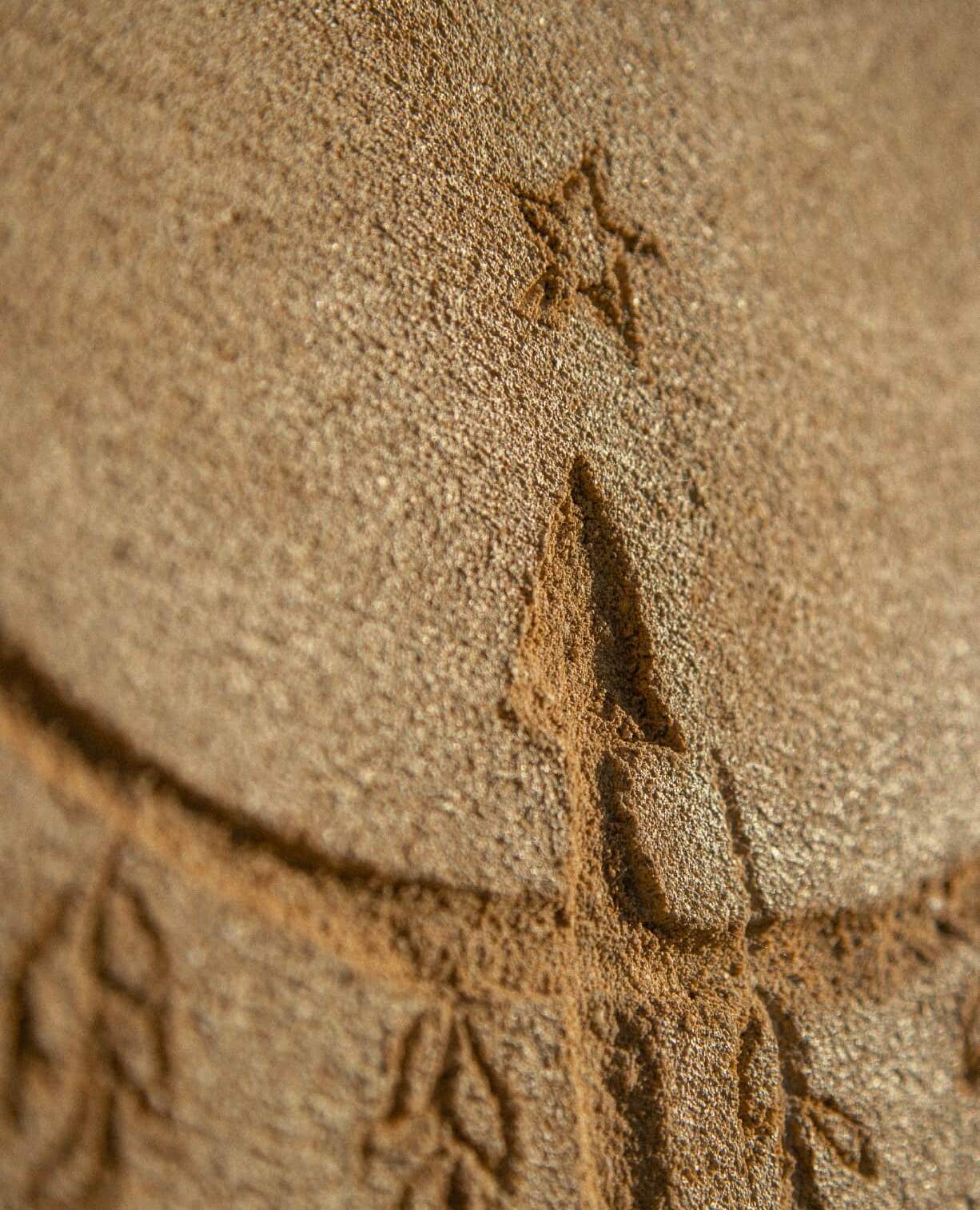 Une étoile et un arbre dessinés dans le sable