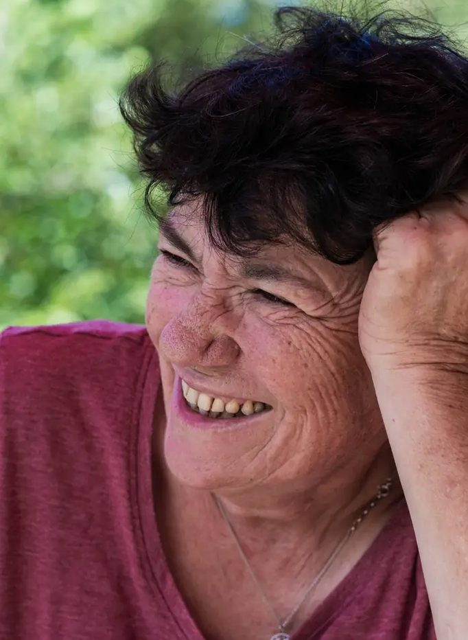 Françoise, tête appuyée sur la main, sourit